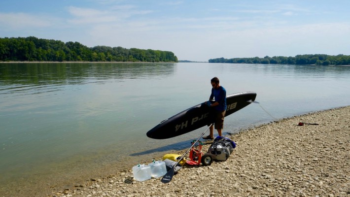 Mark Hines takes a break to check out the condition of his BillboardSUP gear on the banks of the Danube in Austria